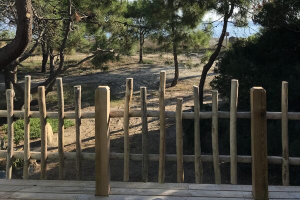 Magnifique vue sur une barrière crée par Ekolinea avec du bois et sur un plancher en bois. Ekolinea est spécialiste en parasols exotiques paillotes.