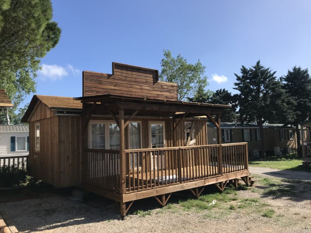 personnalisation mobile home Ekolinea Vue sur un mobil-home avec une façade personnalisée par Ekolinea à partir de bardage de bois. Ekolinea est spécialiste dans la conception et la construction de parasols exotiques paillotes