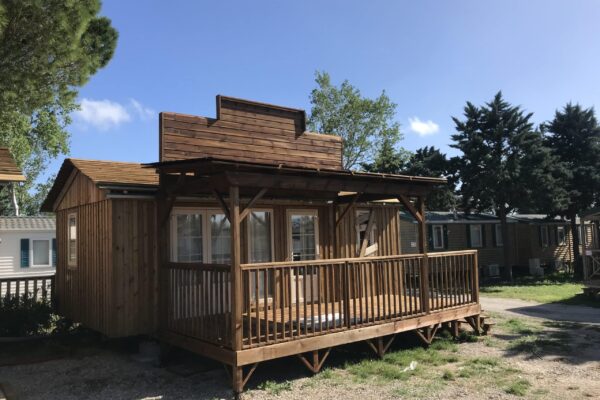 Vue sur un mobil-home avec une façade personnalisée par Ekolinea à partir de bardage de bois. Ekolinea est spécialiste dans la conception et la construction de parasols exotiques paillotes