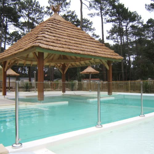 vue sur une paillote recouvrant une partie de la piscine pour créer de l'ombre. La couverture du toit est en roseau de camargue. Ekolinea est spécialiste des Parasols exotiques et paillotes