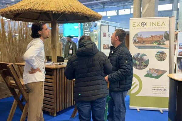 vue sur le stand ekolinea et d'un parasol pailote, avec une couverture en roseaux