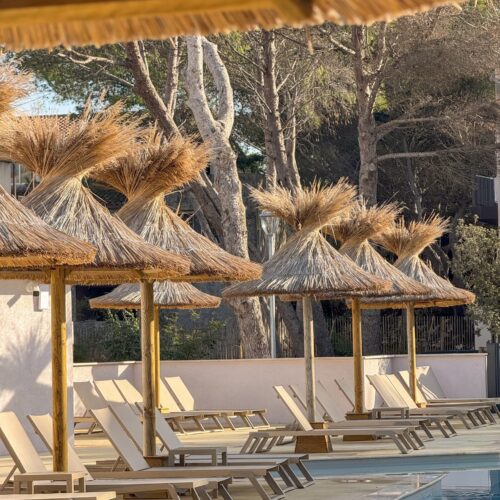 Installation de parasols en roseau de Camargue au bord de la piscine d'une résidence de vacances