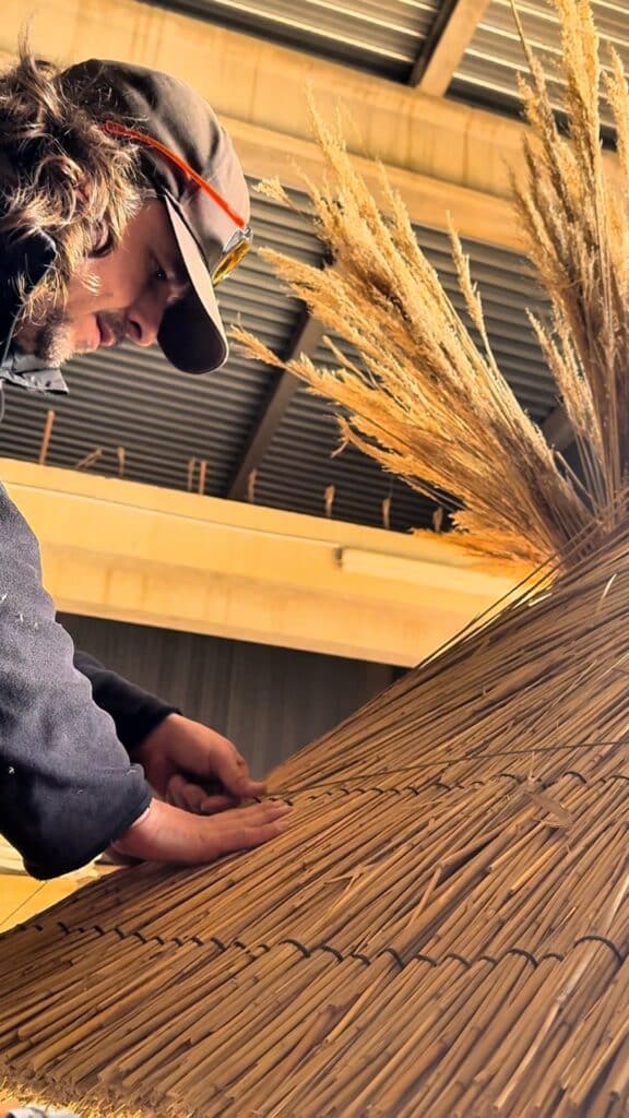 Artisan Ekolinea travaillant sur la fabrication à la main d'un parasol en roseau de Camargue