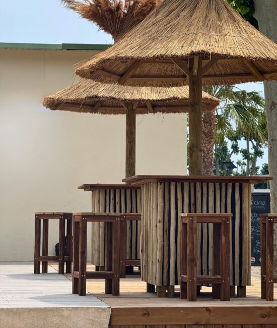Installation d'un parasol en roseau de Camargue et sa table intégrée en bois