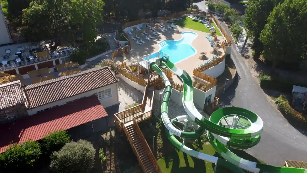 Parasol pailote roseau vue aérienne Vue aérienne de l'espace aquatique d'un camping avec nos parasols paillotes tropicaux en roseau de Camargue, un escalier en bois et des barrières.