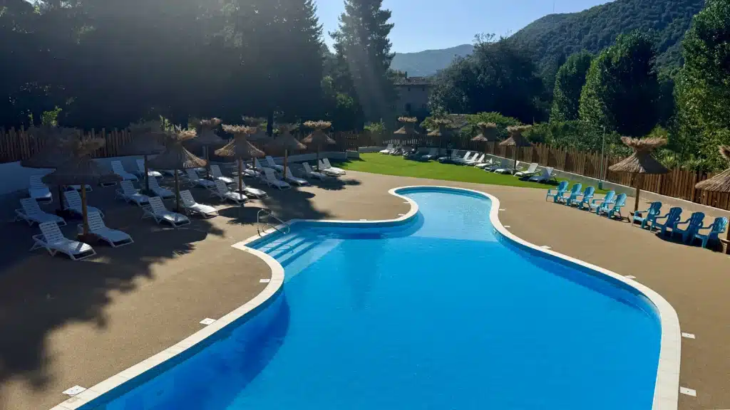 Parasols paillote roseau piscine Installation de parasols paillotes tropicaux en roseau de Camargue dans un camping des Cévennes