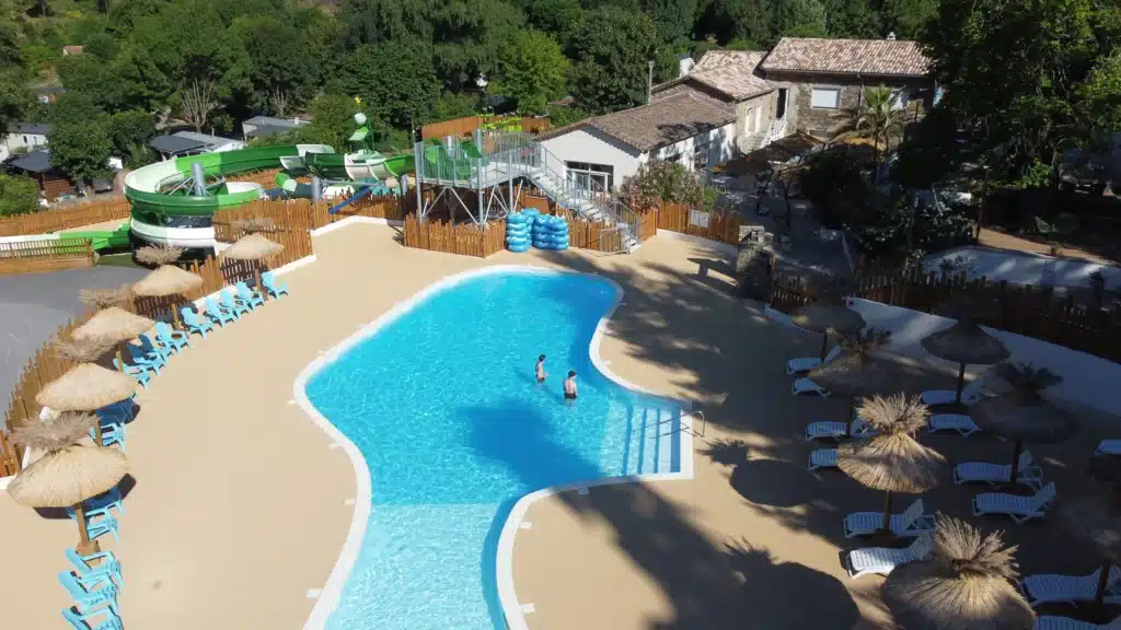 Parasol paillote piscine Fabrication à la main et pose de parasols tropicaux en roseau autour de la piscine du camping Château de l'Hom par Ekolinea