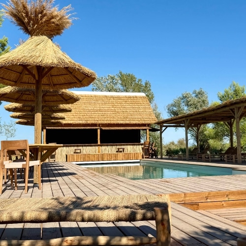 Aménagements extérieurs : parasols roseau avec table, pergolas bois, paillote-bar