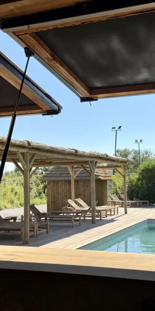 Installation d'un ensemble d'aménagements extérieurs au Mas de Dard : terrasse, pergola sur mesure, parasols en roseau, paillotes sur mesure
