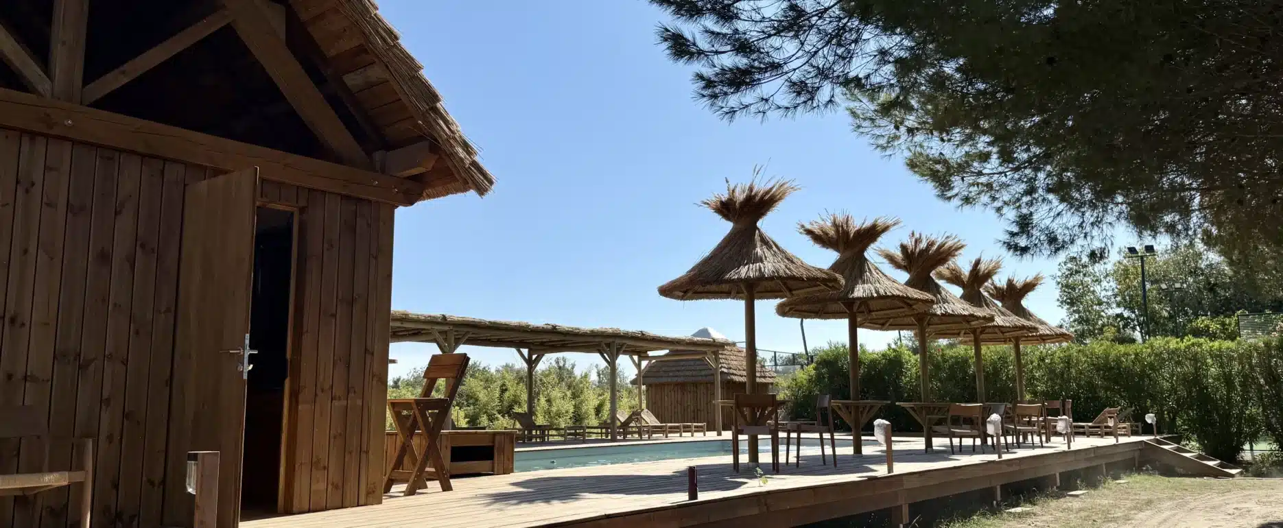 Construction durable : terrasses bois, parasols roseau, paillote bar, pergolas en eucalyptus. Le Mas de Dard a fait confiance a Ekolinea pour ses aménagements extérieurs et constructions durables