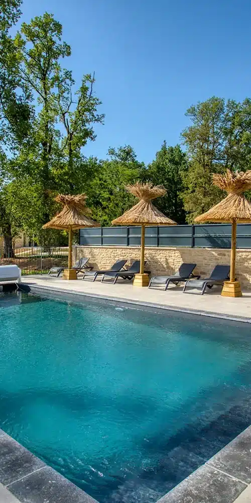 Aménagement extérieur : nos parasols en roseau de Camargue près d'une piscine dans un domaine en Dordogane