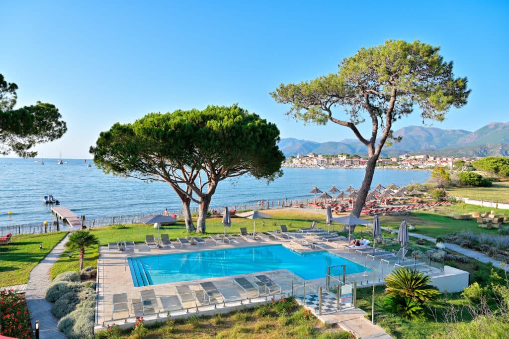 Parasols roseau Camargue hôtel de luxe Vue d'une chambre de l'hôtel 4 étoiles La Roya à Saint-Florent en Corse. INstallation de nos parasols en roseau de Camargue sur la plage.