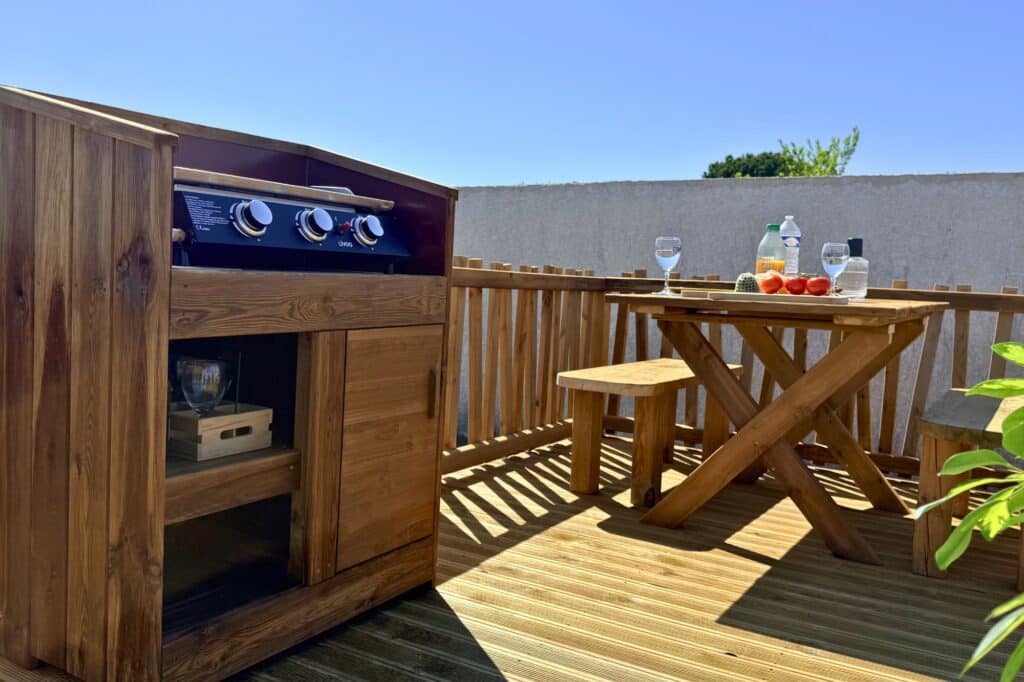 Meuble plancha bois Amenagement d'une terrasse avec une table et ses bancs et un meuble à plancha en bois
