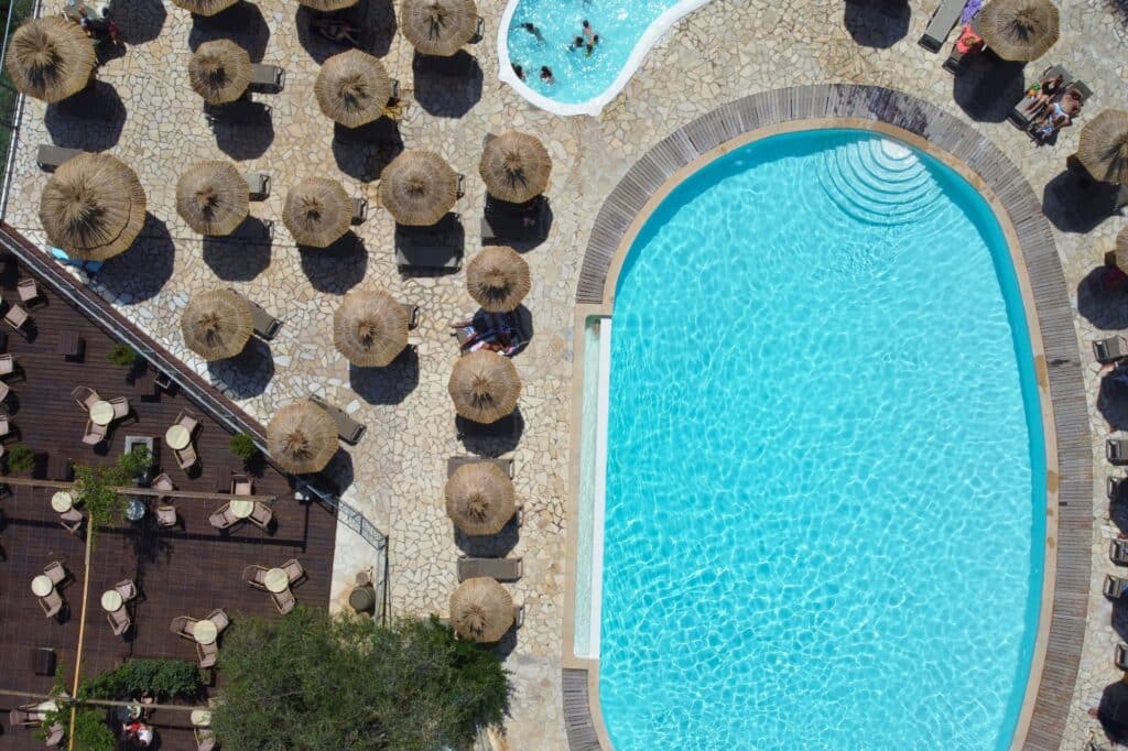 Vue piscine Vigna Maggiore Vue en drone de l'espace aquatique du camping Vigna Maggiore avec des parasols tropicaux